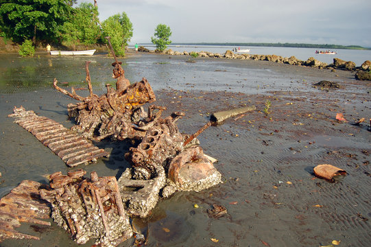 Abandoned rusty metal boat parts at low tide ocean coast