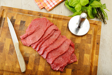 Fettine di carne di manzo crude sul tagliere di legno