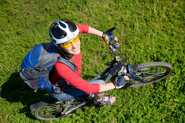 Young cyclist  on green grass