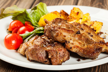 Grilled steaks, baked potatoes and vegetables