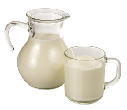 Clear glass jug and mug of milk