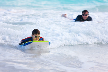Fototapeta na wymiar Father and son surfing