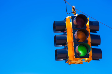 A green traffic light with a sky blue background