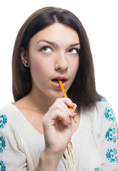 Girl thinking with a pen in mouth, isolated on white.