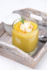 vegetable cream soup with cream and rosemary in a glass
