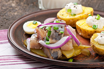 Herring salad with onions and baked potato