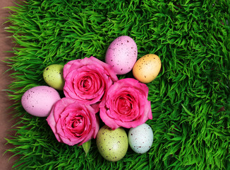 Colorful Easter Egg and Pink Roses on Green Grass