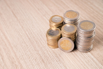 Stapel Euromünzen auf einem Holzbrett