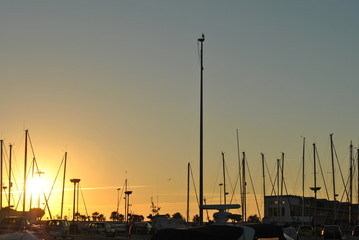 Golden sunset over the marina with sailboat masts in silhouette in Chipiona © cjsolanop
