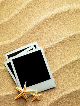 Vintage empty photo frames are lying on the sea sand decorated w