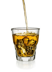 Pouring whisky in glass with ice isolated on white