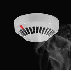 Smoke around fire detector on black background.