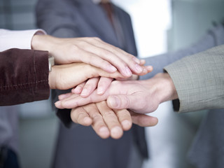 business people putting hands together to show unity