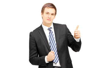 Young businessman in formalwear leaning against wall