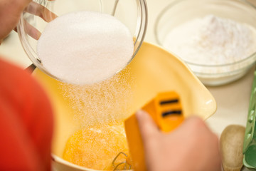 cook hands pouring sugar into bowl