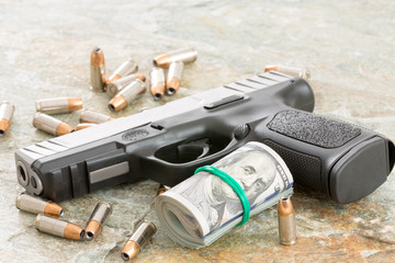 Handgun with money and scattered bullets