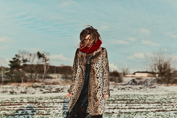 Fashionable girl with dreadlocks in leopard coat for winter