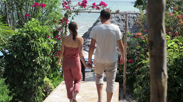 Couple in love walking on stairs in hotel garden
