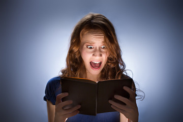 Woman reading horror book nad screaming