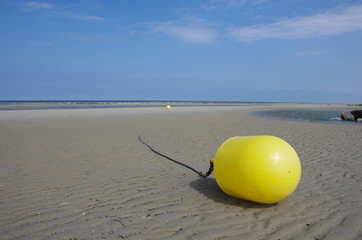 Bouée jaune échouée sur la plage