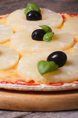 Pizza with pineapple on old table. closeup. Vertical
