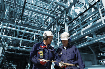 oil workers inside large refinery industry