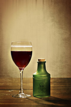 glass red wine with poison bottle