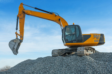 exkavator on big pile of gravel