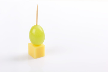 Spit of grape and cheese on white background