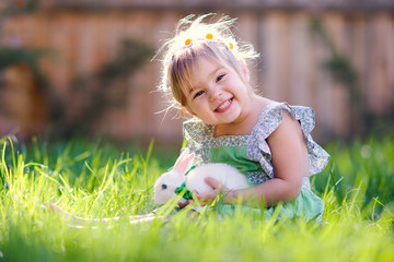 Cute little girl with a bunny rabbit has a easter at green grass