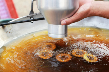 making donut fried in a pan