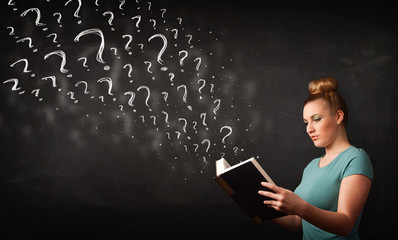 Pretty woman reading a book with question marks coming out from