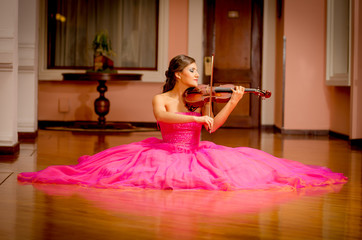 Beautiful woman playing violin with big dress