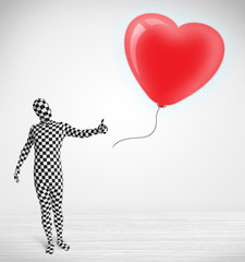 Cute guy in morpsuit body suit looking at a balloon shaped heart
