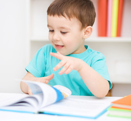 Little boy is reading a book