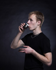 Young man drinking tea on a black