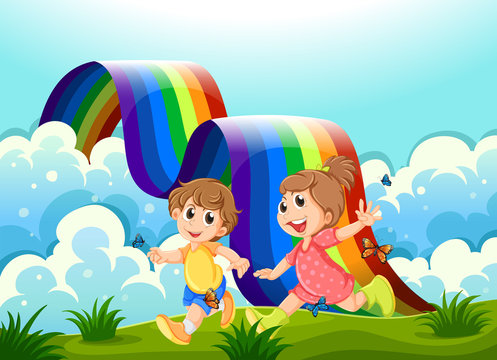 Happy kids playing at the hilltop with a rainbow