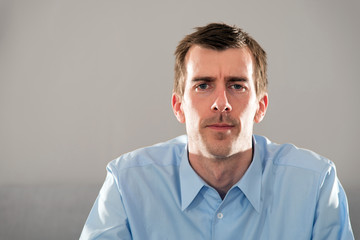 Mimik, Gesicht, junger Mann, blaues Hemd, kurze, dunkle Haare