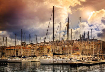 Naklejka premium view of the city and sea port on the background of dramatic suns