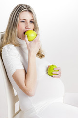 portrait of pregnant woman eating green apple