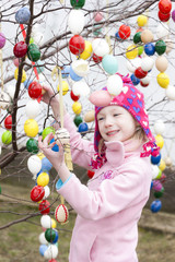 Fototapeta na wymiar little girl standing by Easter tree