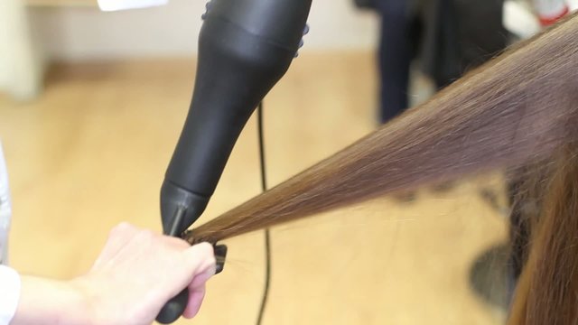 Footage of barber dries hair of model