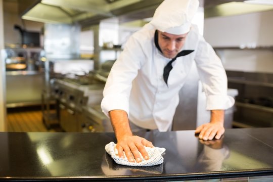 Male Cook Wiping The Kitchen Counter