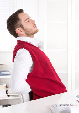 Mann mit Rückenschmerzen sitzend im Büro