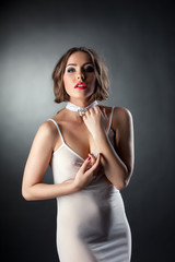 Naklejka premium Attractive sexy woman posing in white negligee