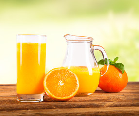 Naklejka na ściany i meble Fresh orange juice and fruits on wood plant