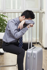 .Businessman resting head on pile of boot.