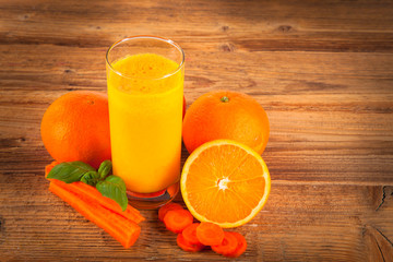 Fresh orange and carrot juice on wood 