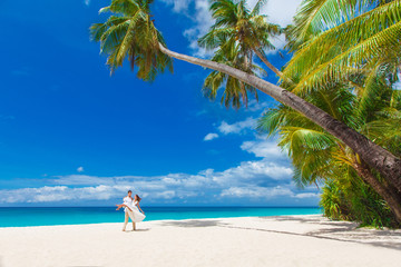young loving couple on tropical beach with palm trees, wedding o
