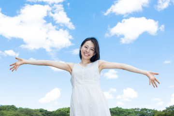 Fototapeta na wymiar 青空に手を広げる女性